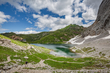 Naklejka na ściany i meble Mountain hiking Trail Road. Small mountain lake. Between Italy and Austria: Volaia Lake Raunchkofer Mountain (Lago di Volaia Monte Rauchkofel)