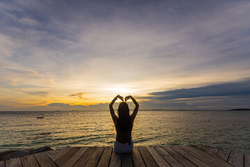 Fototapeta premium silhouette of woman jumping on the sea at sunset. soft focus and low key