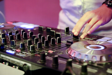 Obraz premium DJ's hand playing music with a mixer console at a party