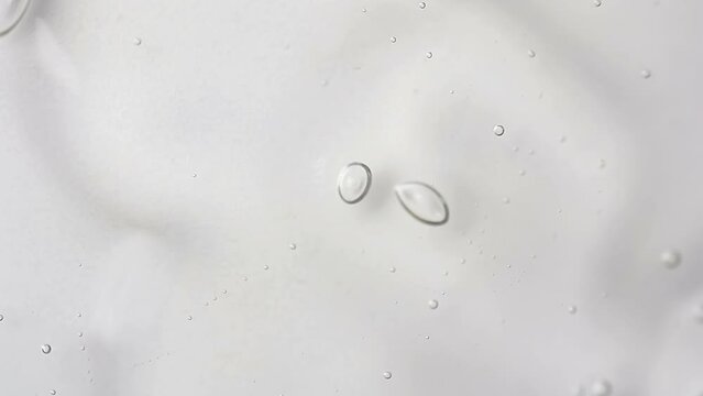 Pouring clean transparent shampoo with bubble ffrom bottle. Macro cosmetic, cleaner texture background, isolated on white