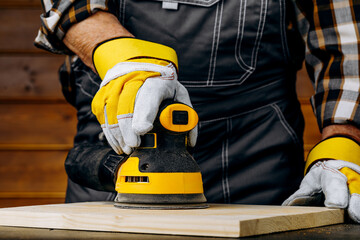 Close up of sending a wood with orbital sander at workshop