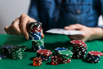 A woman plays in a casino. opening cards to raise bets. Against the background of chips. Poker...