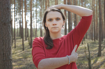 Person practicing EFT in nature forest. Female tapping point under arm. Emotional freedom technique concept.