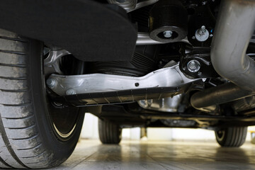 View of a modern car from below. Vehicle suspension components. Auto parts and repair. Selected focus.