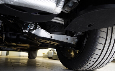 View of a modern car from below. Vehicle suspension components. Auto parts and repair. Selected focus.