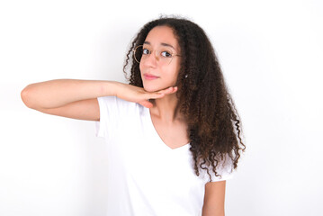 Teenager girl with afro hairstyle wearing white T-shirt over white wall  cutting throat with hand...