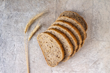 slices of whole grain bread and spikelets on a light background