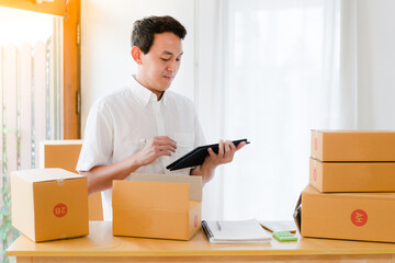 Fototapeta na wymiar person moving boxes , Portrait of Asian man packing box and check list in the office business , SME internet work from home business 