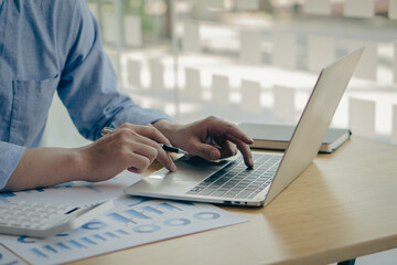 Fototapeta premium businessman hands working on laptop computer data analysis financial chart review online work concept