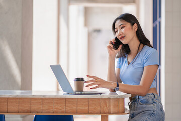 Asian woman talking on smartphone writing laptop working online beautiful girl at startup desktop, business, asia, woman, online, SME, telemarketing,