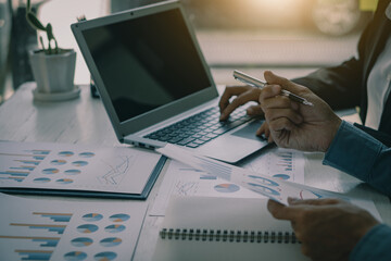 Obraz na płótnie Canvas businessman hands working on laptop computer data analysis financial chart review online work concept