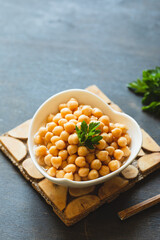 Cooked chickpeas in white bowl. Ingredient for Tasty vegetarian food. Boiled chickpeas, selective focus