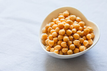 Cooked chickpeas in white bowl. Ingredient for Tasty vegetarian food. Boiled chickpeas, selective focus