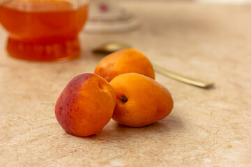 Apricot. Ripe Organic Apricots, Homemade jam in a glass, a spoon on a table. Preserved berries,...