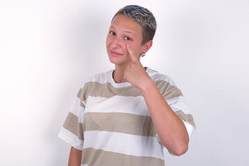 young woman with short hair wearing striped t-shirt over white background, looking, observing,...