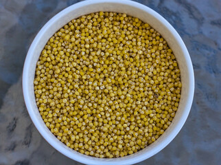 Yellow grains of millet in a deep plate.