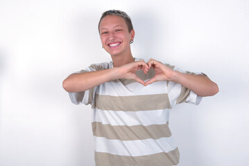 young woman with short hair wearing striped t-shirt over white background smiling in love showing...