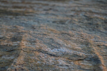 Rough texture of fine natural stone, photographed during golden hour, selective focus