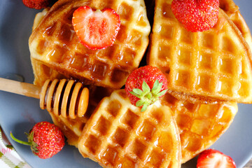 Soft waffles strawberries and poured with honey.
