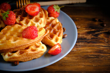 Soft waffles strawberries and poured with honey.