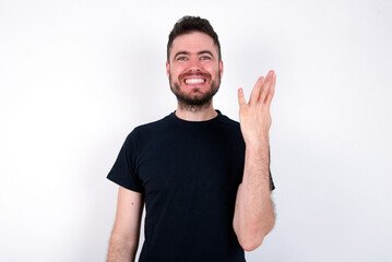 young caucasian bearded man wearing black t-shirt standing over white wall smiling and looking friendly, showing number four or fourth with hand forward, counting down