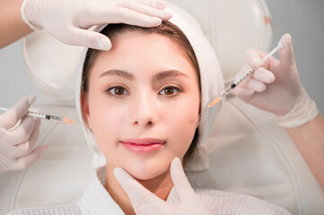 Female making mesotherapy beauty care with anti-aging of face in surgery clinic.