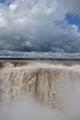 The photo shows a stunning view from the top of the Iguazu Falls — a complex of 275 waterfalls on the Iguazu River, located on the border of Brazil and Argentina