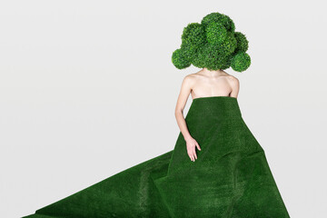 a naked young guy in a mask in the form of a huge broccoli is hiding behind an artificial turf - obrazy, fototapety, plakaty