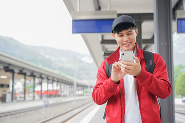 close up traveler asian man hand use smartphone for checking timetable at public train station in...