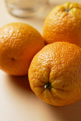 Close up of three oranges on yellow background