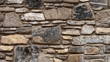 Nice colorful stone wall in brown, black tones, close up, background