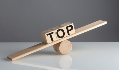 TOP text on wooden cubes on a wooden balance , business concept
