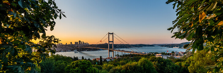 Fototapeta na wymiar ISTANBUL, TURKEY. Panoramic view of Istanbul Bosphorus on sunset. Istanbul Bosphorus Bridge (15 July Martyrs Bridge. Turkish: 15 Temmuz Sehitler Koprusu). Beautiful cloudy blue sky.