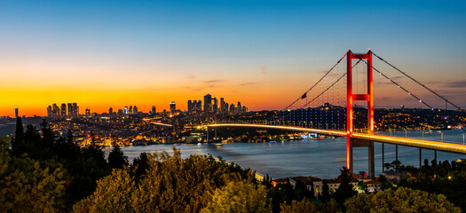 ISTANBUL, TURKEY. Panoramic view of Istanbul Bosphorus on sunset. Istanbul Bosphorus Bridge (15 July Martyrs Bridge. Turkish: 15 Temmuz Sehitler Koprusu). Beautiful cloudy blue sky.