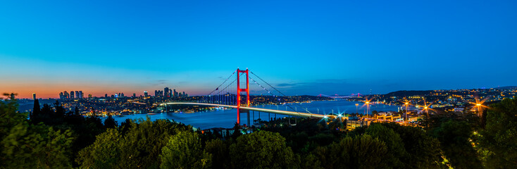 Naklejka premium ISTANBUL, TURKEY. Panoramic view of Istanbul Bosphorus on sunset. Istanbul Bosphorus Bridge (15 July Martyrs Bridge. Turkish: 15 Temmuz Sehitler Koprusu). Beautiful cloudy blue sky.