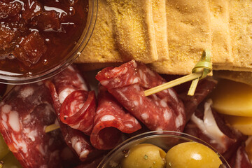 close up of charcuterie board with different types of nuts, salami, crackers, olives and cheese