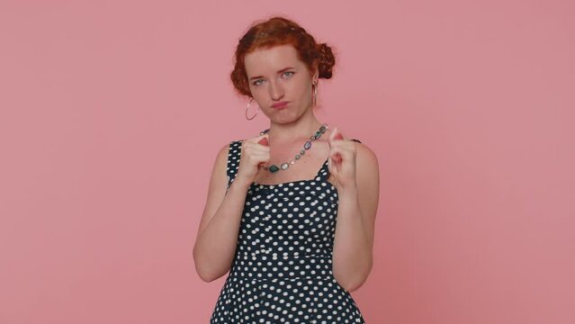 Greedy avaricious redhead young woman showing fig negative gesture, you dont get it anyway. Rapacious, avaricious, acquisitive. Body language. Refusal fig sign. Ginger girl indoor on pink background