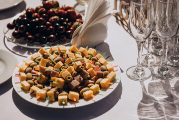 on a taralka cheese platter with olives and pieces of ham. Snack