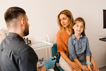 Woman and her child daughter visit ENT doctor. Consultation about endoscopy of nose for family with...