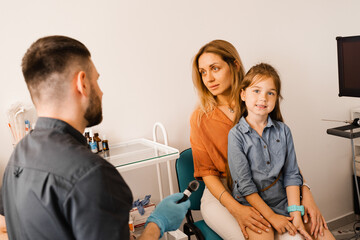 Woman and her child daughter visit ENT doctor. Consultation about endoscopy of nose for family with...