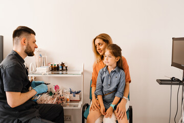 Woman and her child daughter visit ENT doctor. Consultation about endoscopy of nose for family with...