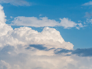 Picturesque cumulus clouds against the blue sky illuminated by the bright sun. Sky with cumulus clouds