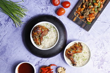 Fried rice with chicken prepared and served in a wok natural wood in the background top view