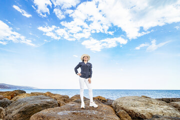 Obraz premium woman standing on the rocks on the sea