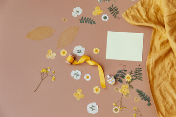 Spring or wedding or birthday mock up scene. Blank open sheet of paper and flowers with place for text for greeting card copy space. Flat lay, top view