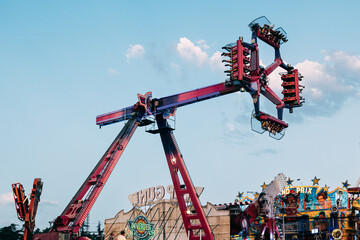 View of a extreme attraction and different games in an amusement park. Entertainment, adrenaline...