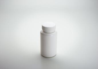 White Medicine bottle on neutral white background, with natural shadows. Blank label. 