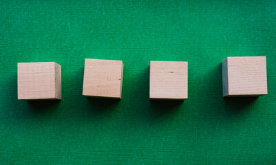 Four wooden cubes on a green background, mocap