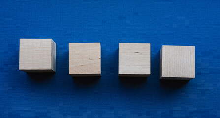 Four wooden cubes on a blue background, mocap