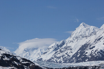 Fototapeta na wymiar Orbital cloud formation (lenticular clouds) around an Alaskan mountain range with peak
